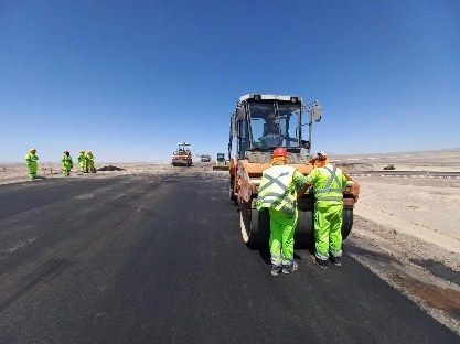 Cuadrilla junto al rodillo sobre carpeta recién colocada en Arica