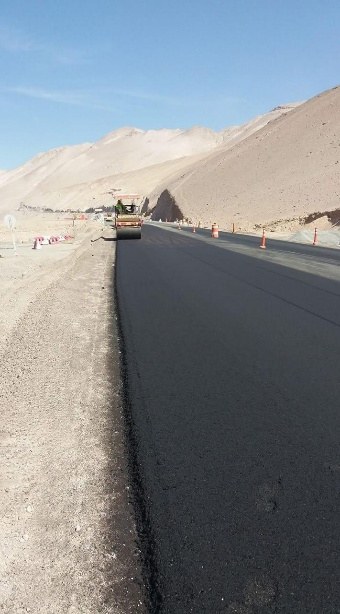 Carpeta asfáltica recién colocada junto al cerro en la Ruta 11-CH