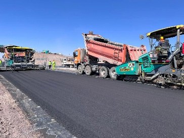 Camiones tolva alimentando la extendedora en Calama